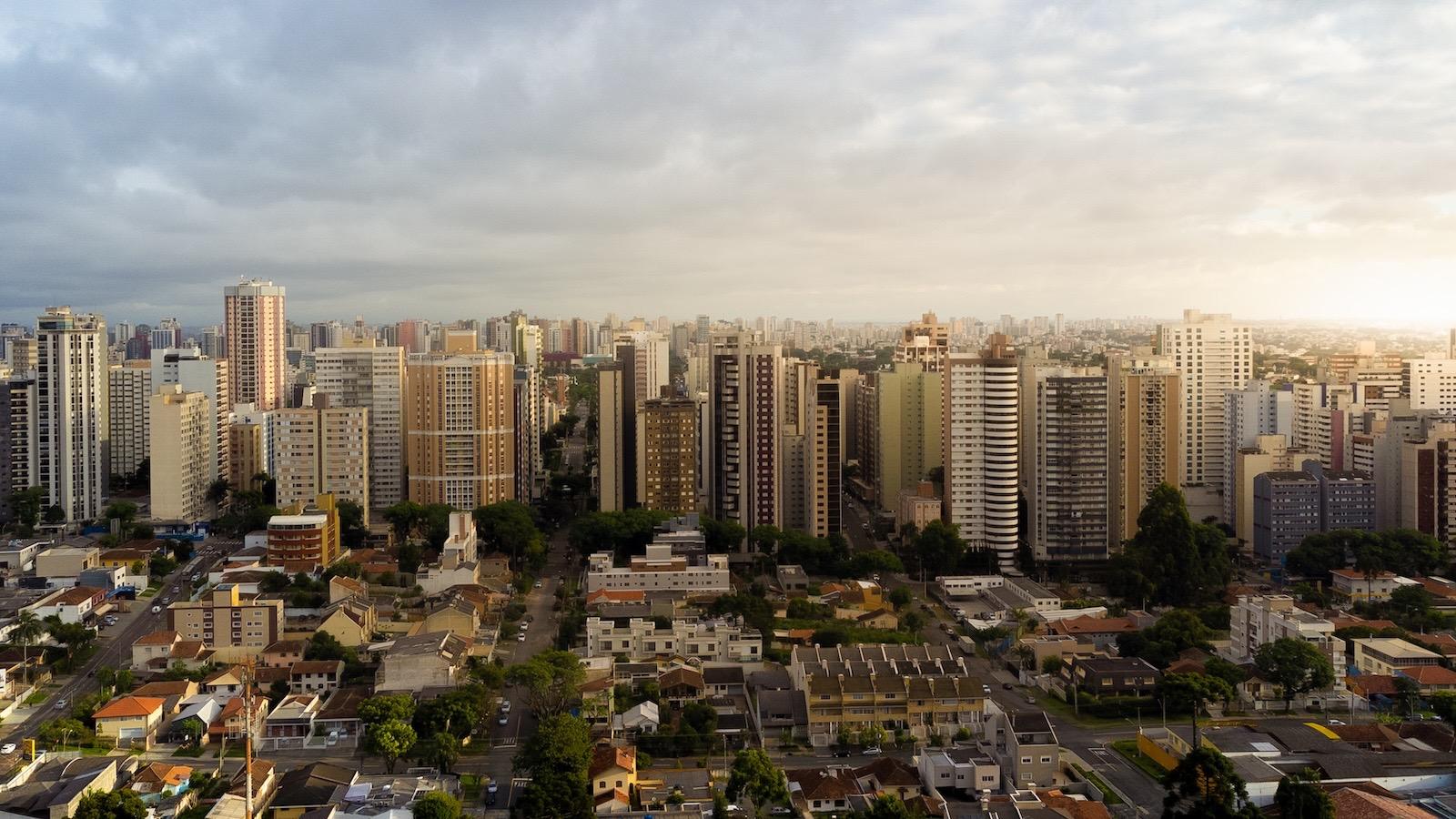 Rua arborizada com casas no bairro Ahú, em Curitiba